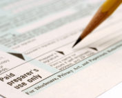 A person signing the document with pencil