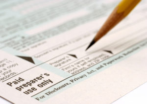 A person signing the document with pencil