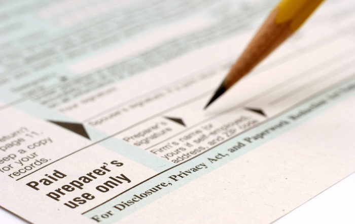 A person signing the document with pencil